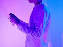 Caucasian man in a studio with vibrant lighting interacting with a digital interface.